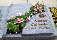 Geschwungene Grabplatten als Viertelkreise mit Blumen